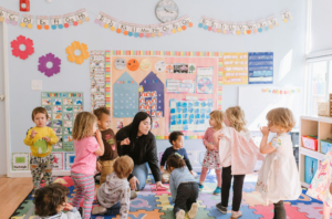 Children playin in preschool with a teacher.
