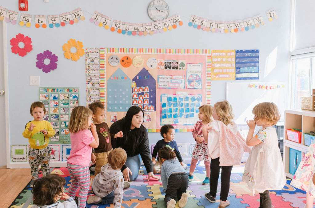 Children playin in preschool with a teacher.