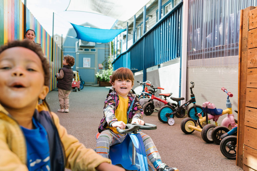 Child on a big wheel in preschool.