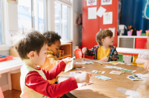 Kids playing at a table with cards.