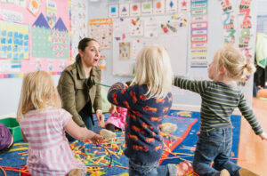 Kids working with a teacher building with toys