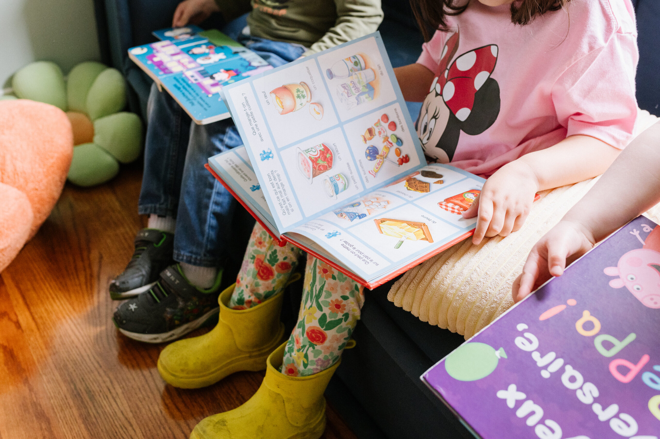 Kids reading out of books with rainboots on