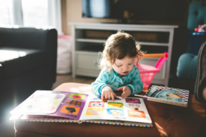 A toddler reading a book at daycare